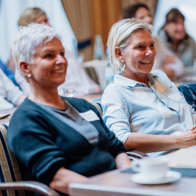 es werden lachende Fachtag-Teilnehmerinnen gezeigt